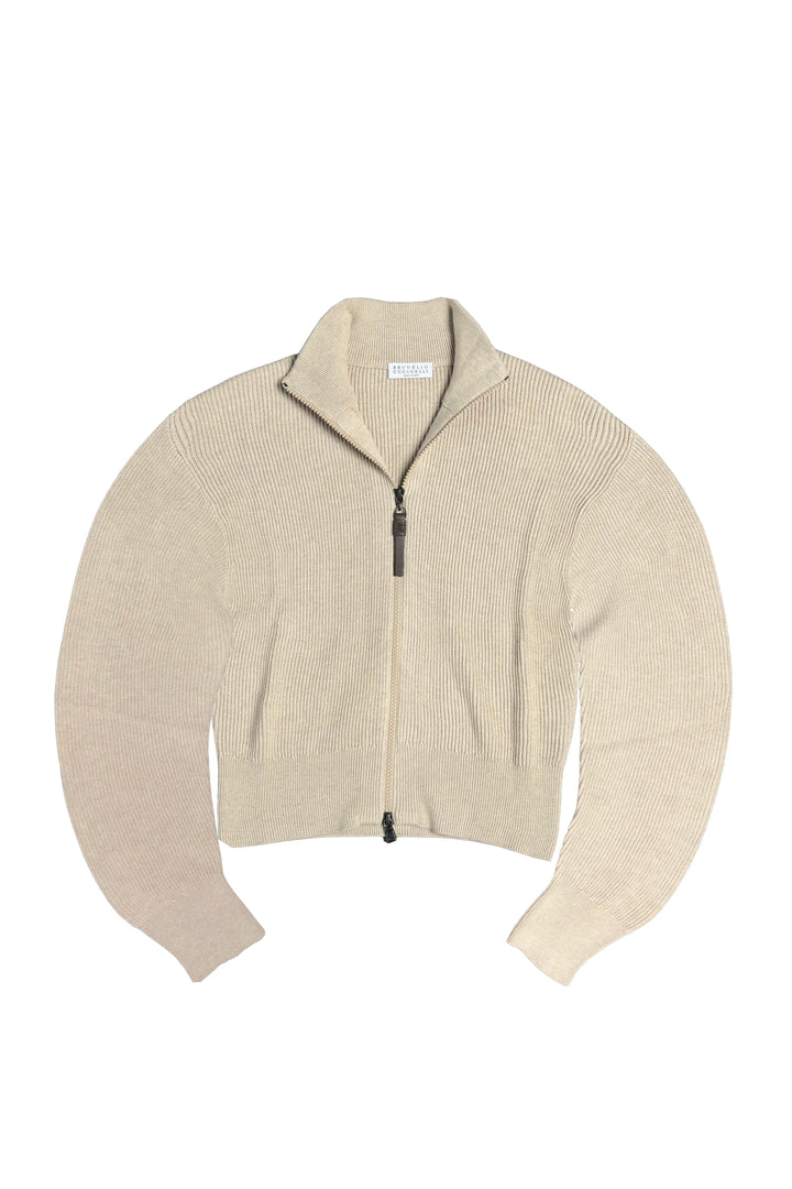 A cropped ribbed knit zip-up sweater in a light beige or cream color, featuring a mock neck and long sleeves, laid flat against a white background.