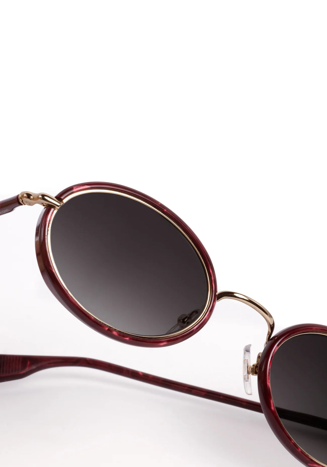 Sunglasses with red frame and dark lenses on a white background