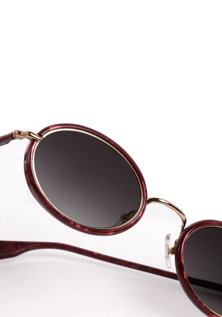 Sunglasses with red frame and dark lenses on a white background