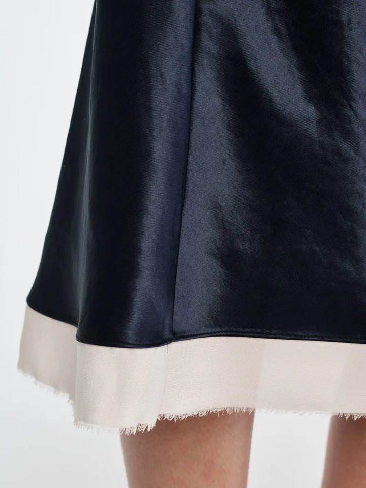 Navy blue skirt with white hem on a light gray background