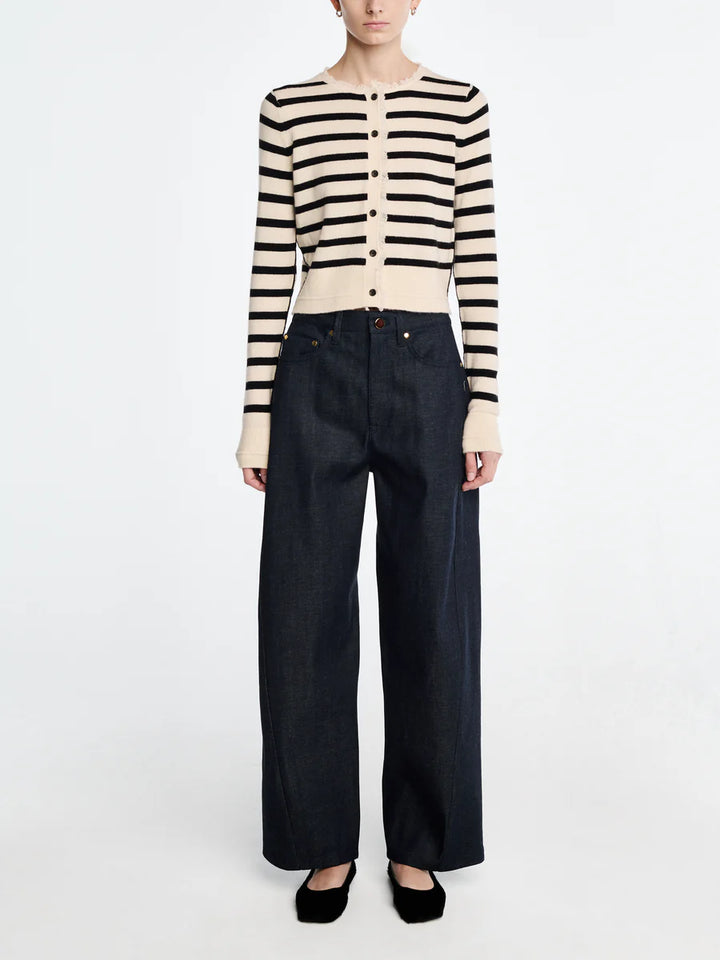 Person wearing a striped sweater and dark jeans on a white background