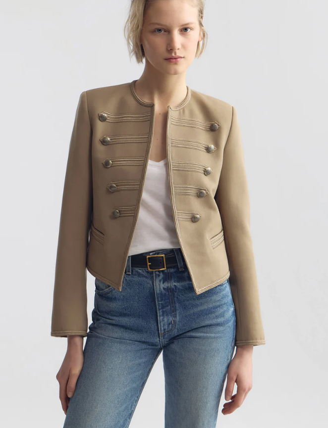 Woman wearing a beige jacket and blue jeans on a white background