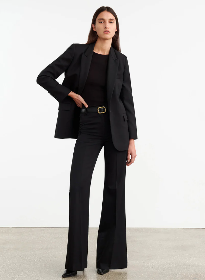 Woman wearing a black suit with a white background