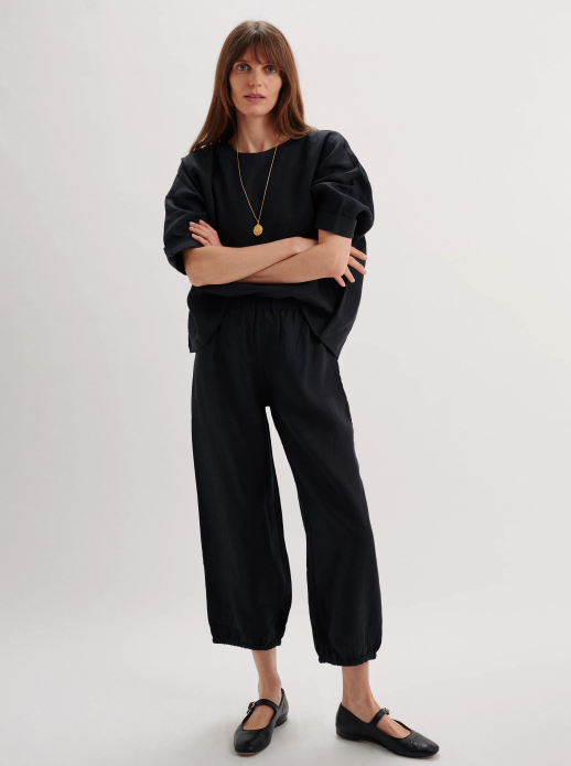 Woman wearing a black outfit with a plain background