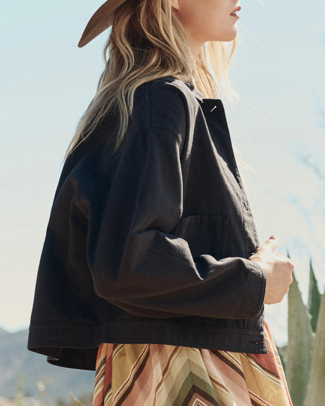 Person wearing a black jacket with a scenic background