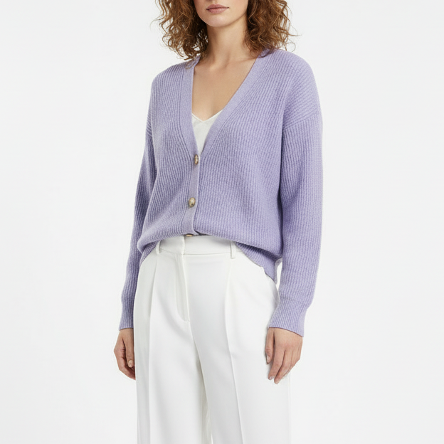 Woman wearing a light purple cardigan over a white top and pants on a white background
