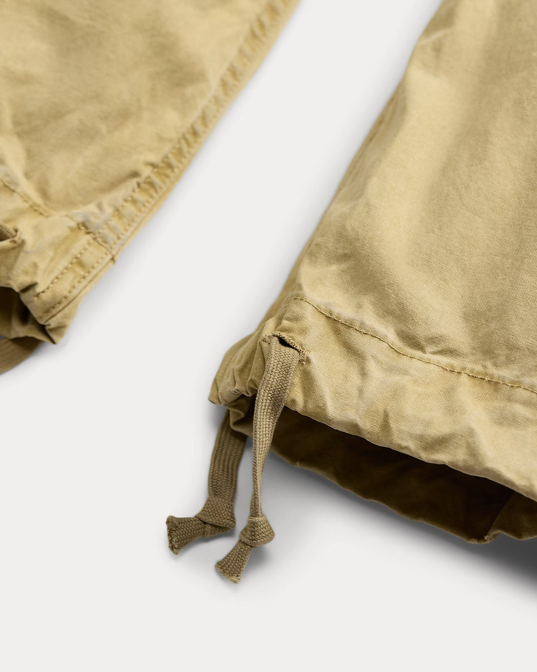 Close-up of beige fabric with a drawstring on a white background