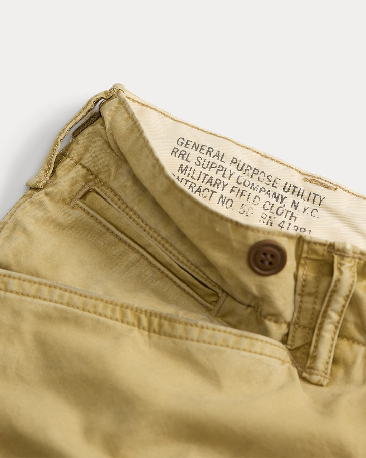 Close-up of beige pants with a label on a light gray background