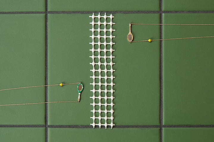 Tennis court with a green mat, racket, and ball on a green surface