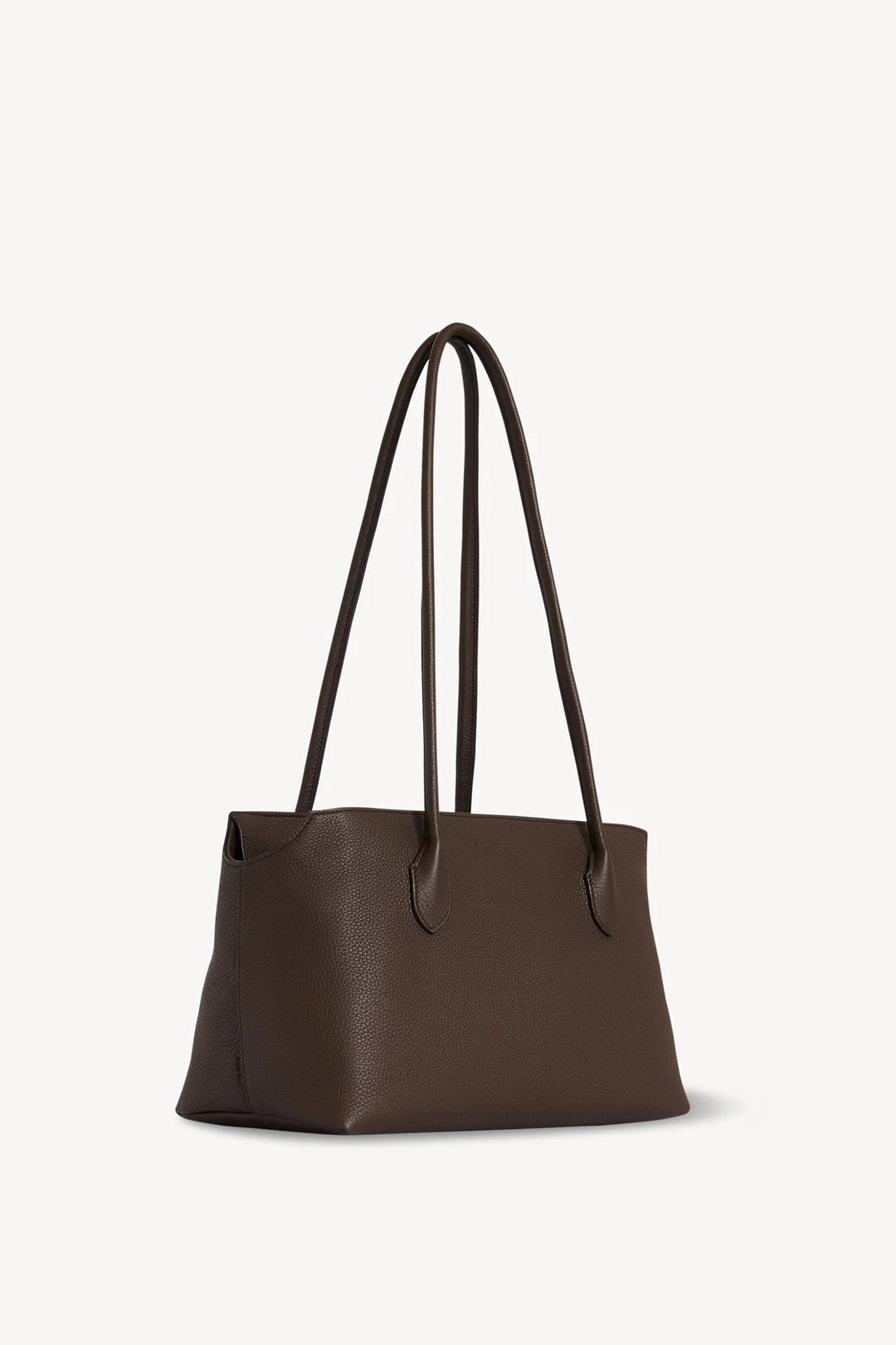Brown leather tote bag with black handles on a white background