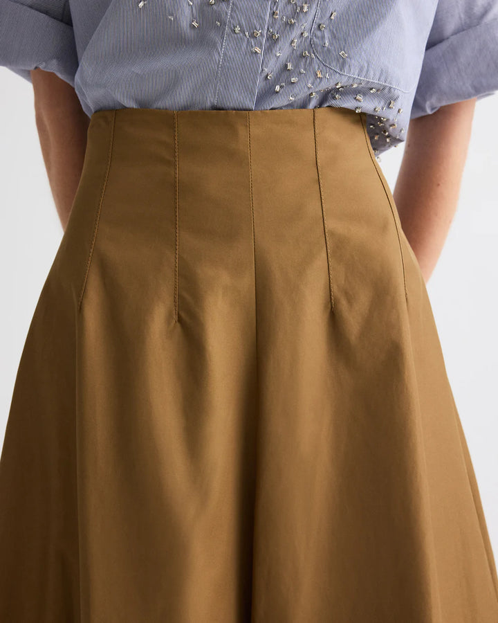 Brown skirt worn with a blue shirt on a white background