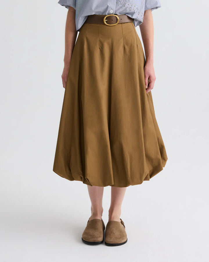 Person wearing a brown skirt with a belt on a white background
