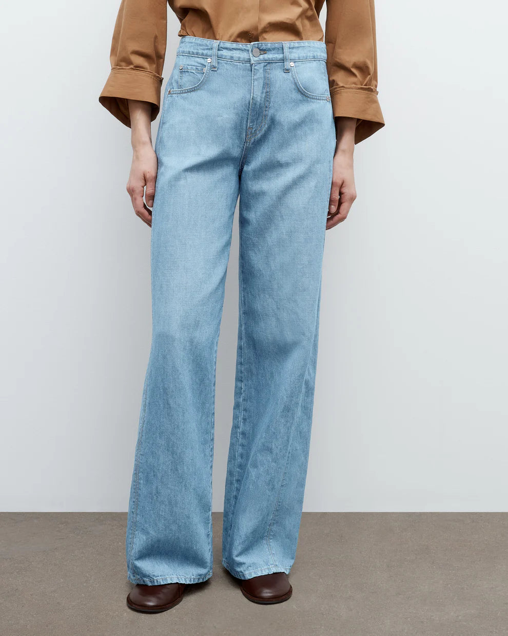 Light blue jeans worn by a person on a plain background