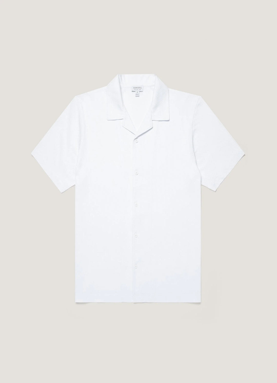White polo shirt on a beige background