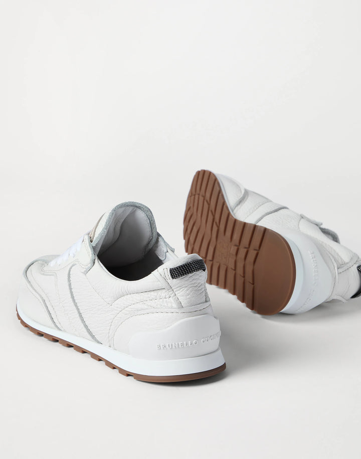 White sneakers with brown soles on a light gray background