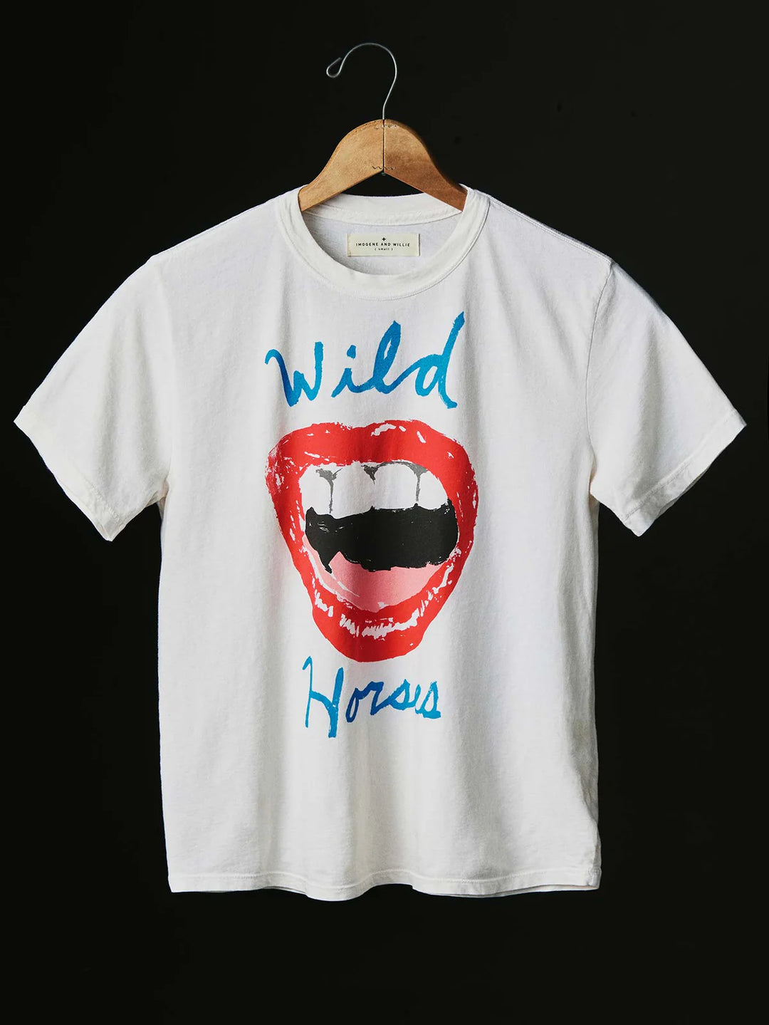 White t-shirt with a graphic of a red lip and tongue, with 'Wild Horses' text, on a hanger against a black background.