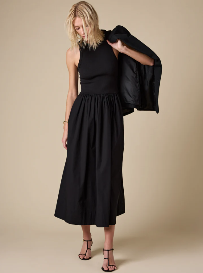 Woman wearing a black dress against a beige background