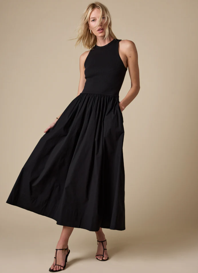 Woman wearing a black sleeveless dress against a beige background