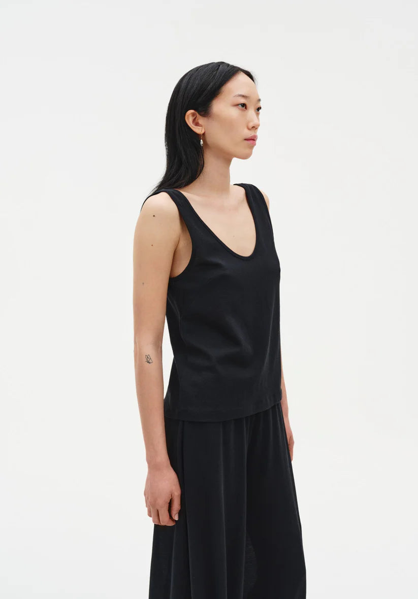 Woman wearing a black sleeveless top and skirt on a white background