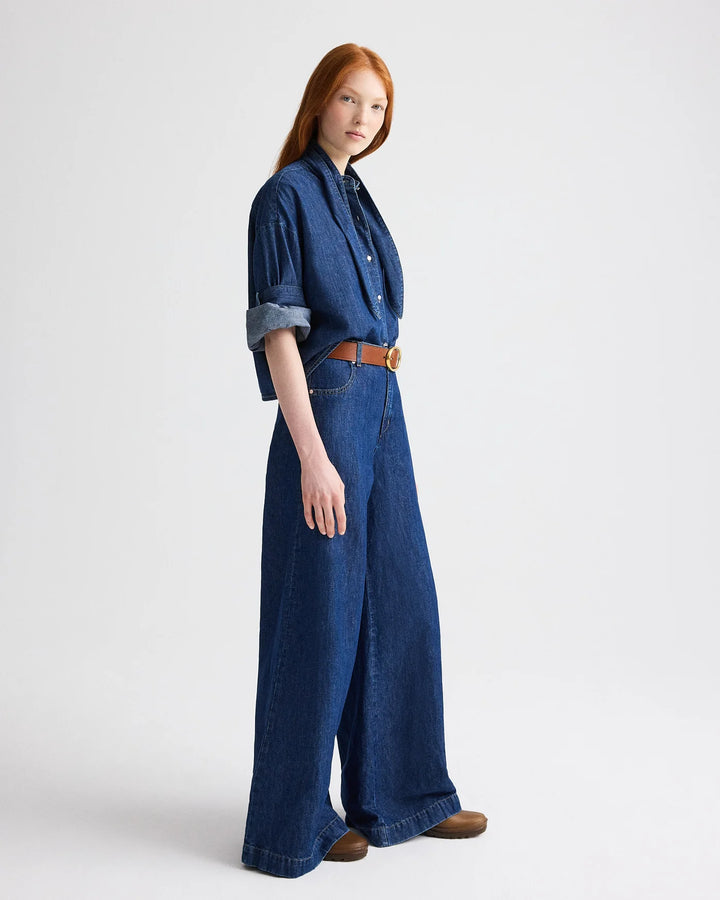 Woman wearing a blue denim outfit on a white background
