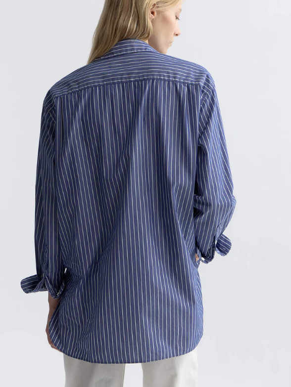 Woman wearing a blue striped shirt against a white background