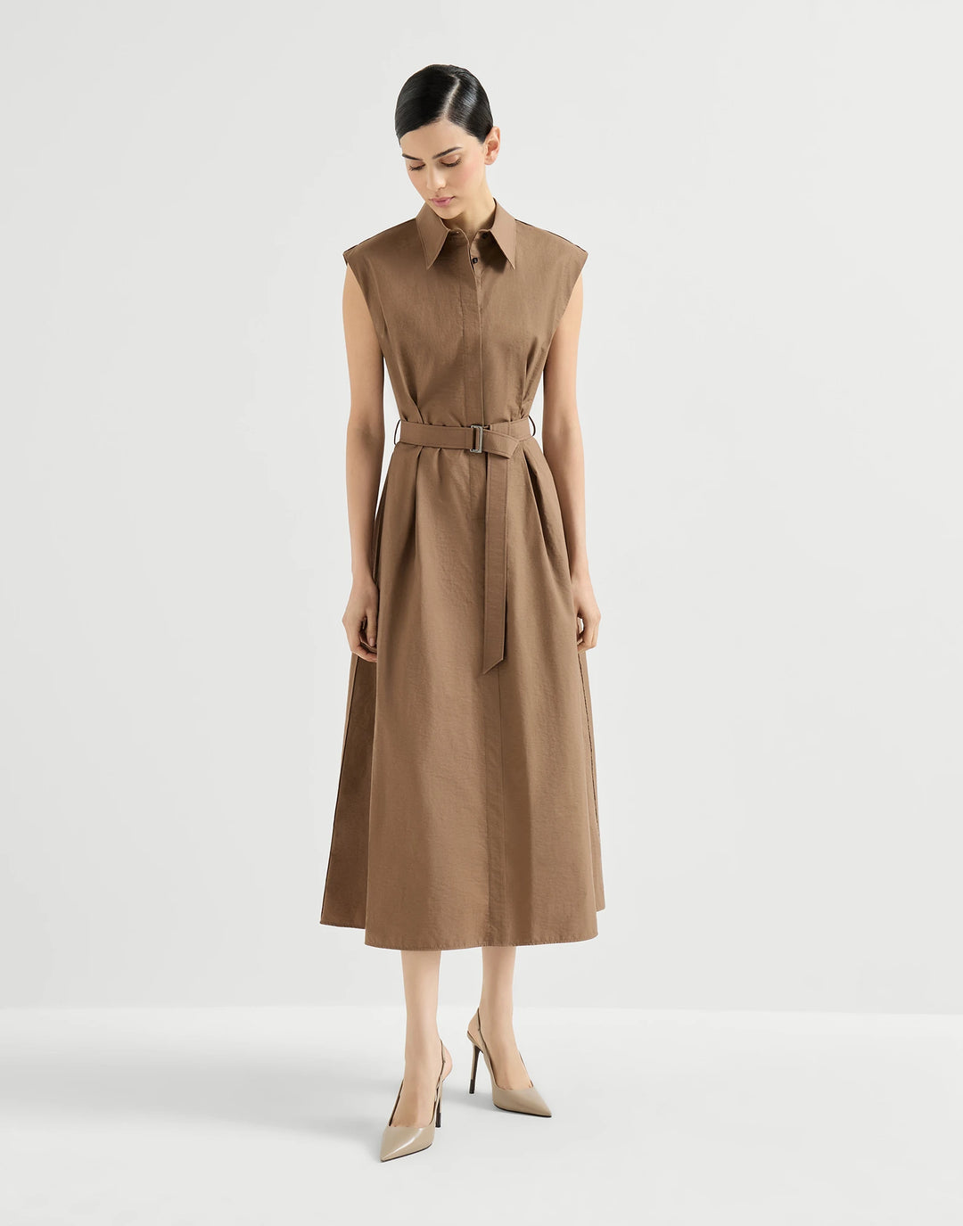Woman wearing a brown dress with a belt on a white background