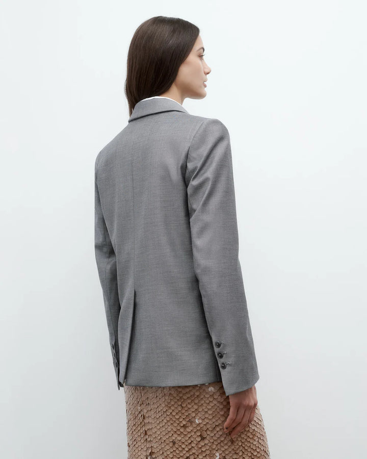 Woman wearing a gray blazer on a white background