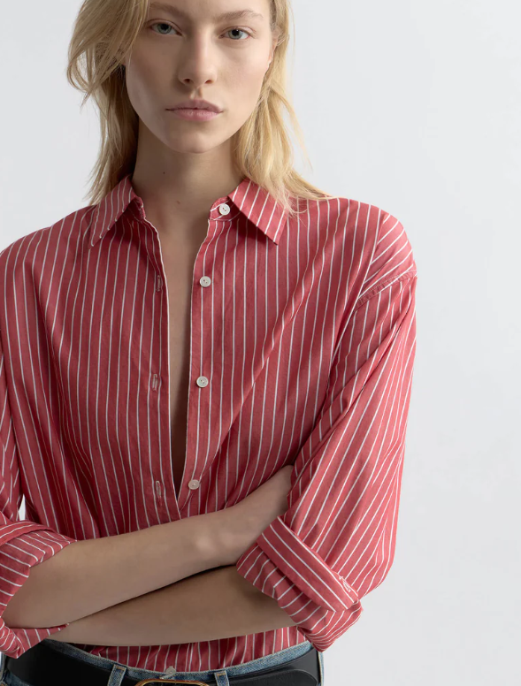 Woman wearing a red and white striped shirt against a plain background