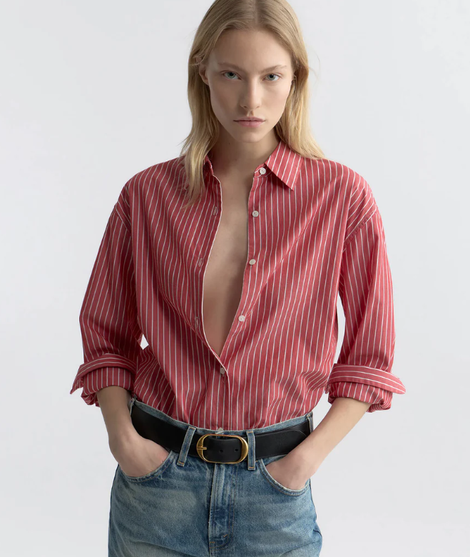 Woman wearing a red striped shirt and blue jeans on a white background