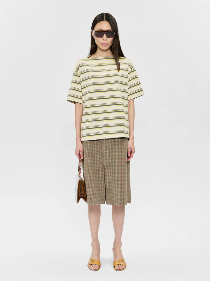 Woman wearing a striped shirt and skirt with sunglasses on a white background
