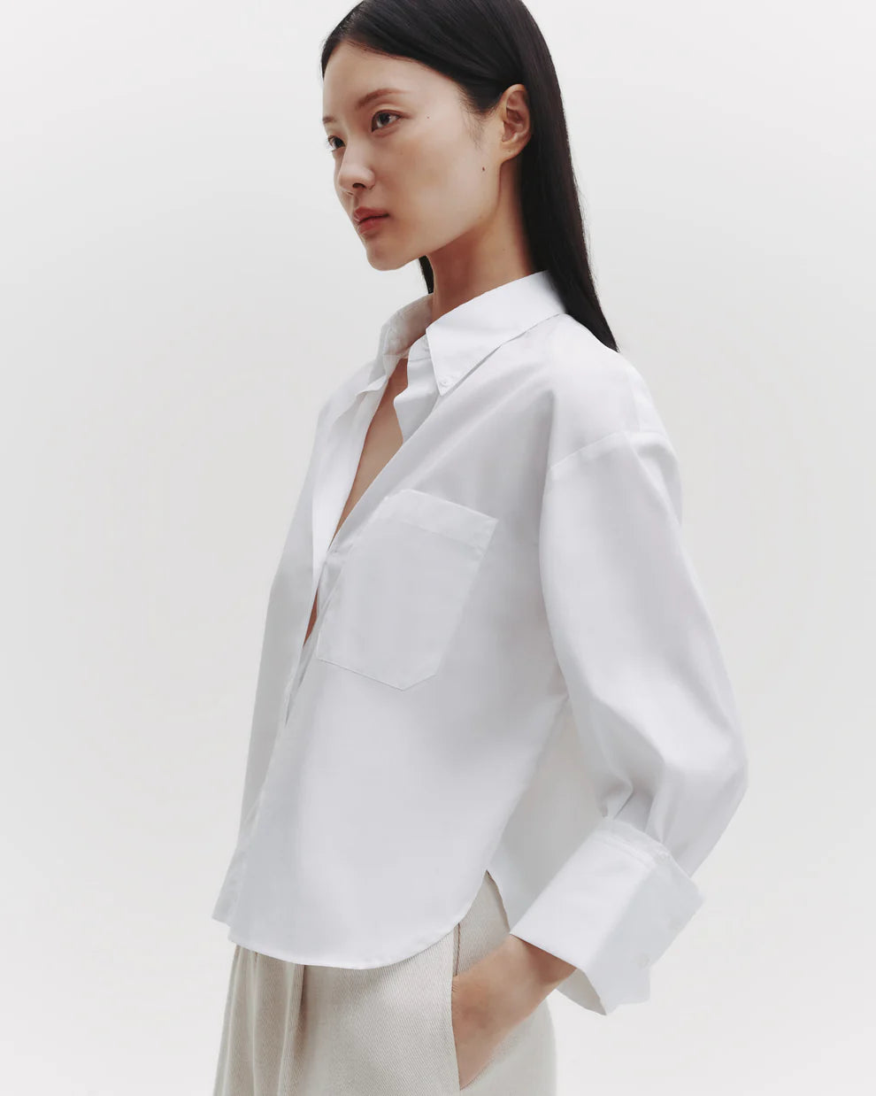 Woman wearing a white blazer against a plain background