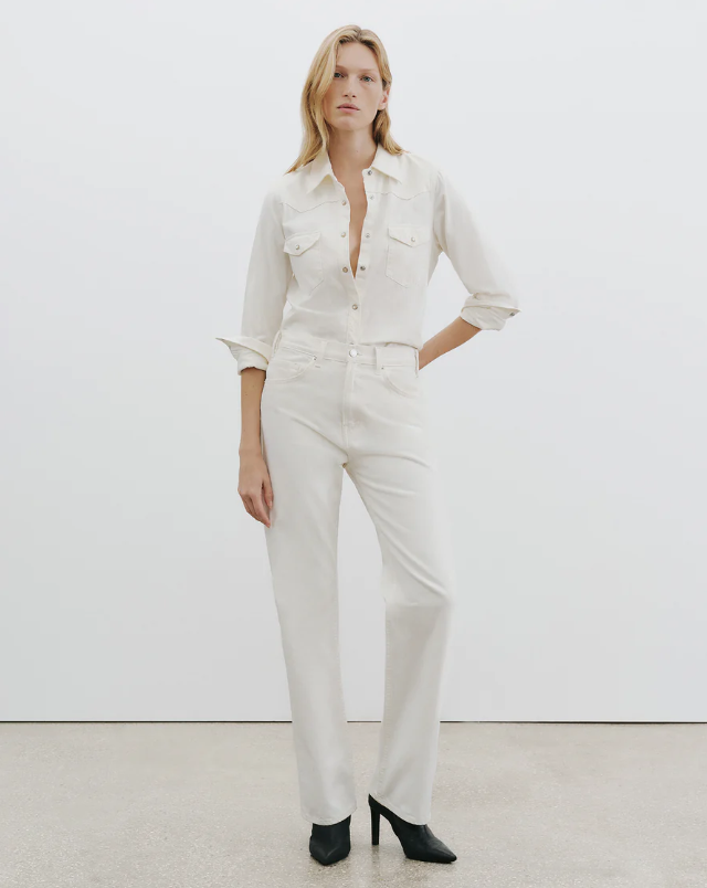 Woman wearing a white outfit against a plain background