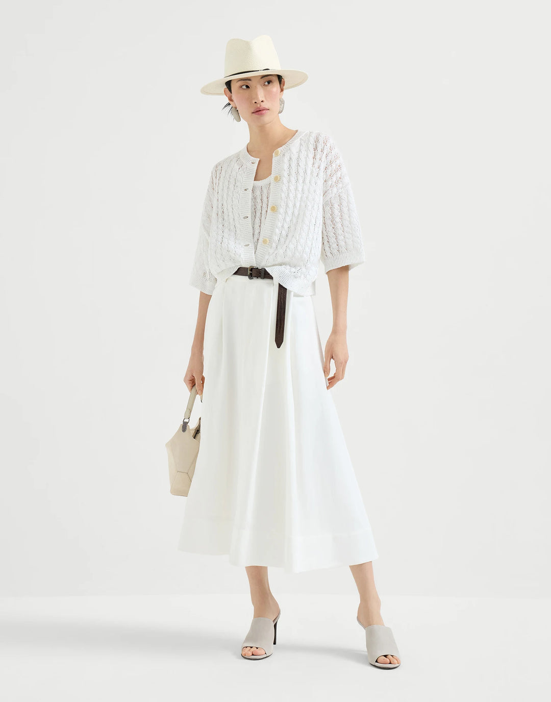 Woman wearing a white outfit with a hat on a white background