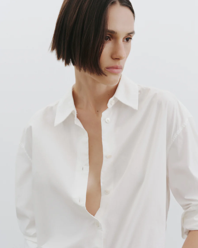 Woman wearing a white shirt against a plain background