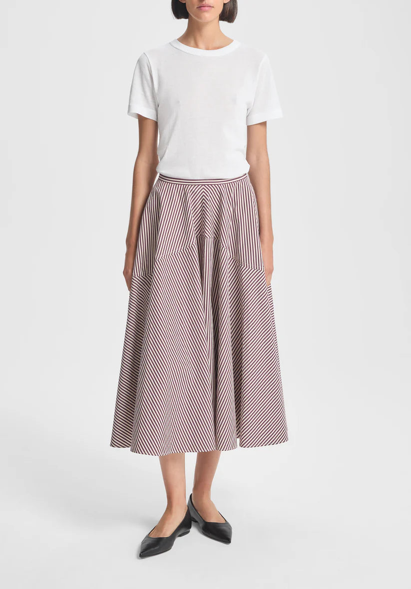 Woman wearing a white top and striped skirt on a white background