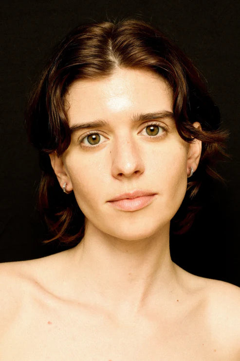 Woman with a neutral expression against a black background