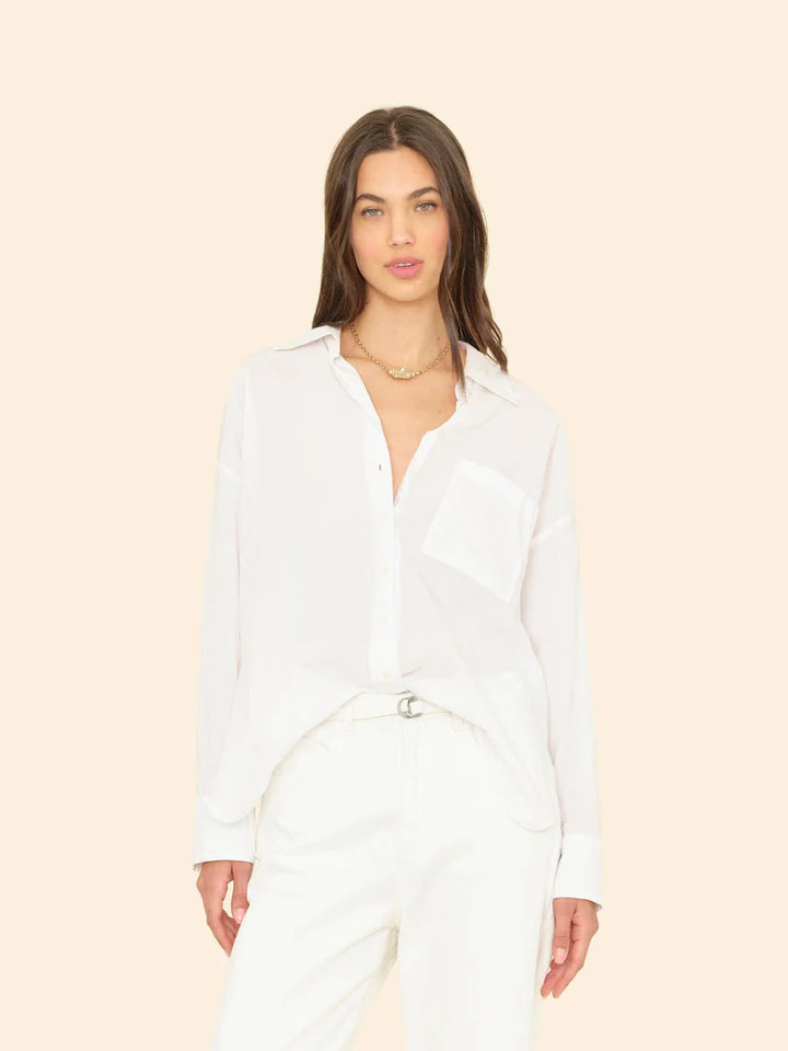 Woman wearing a white shirt and pants on a beige background