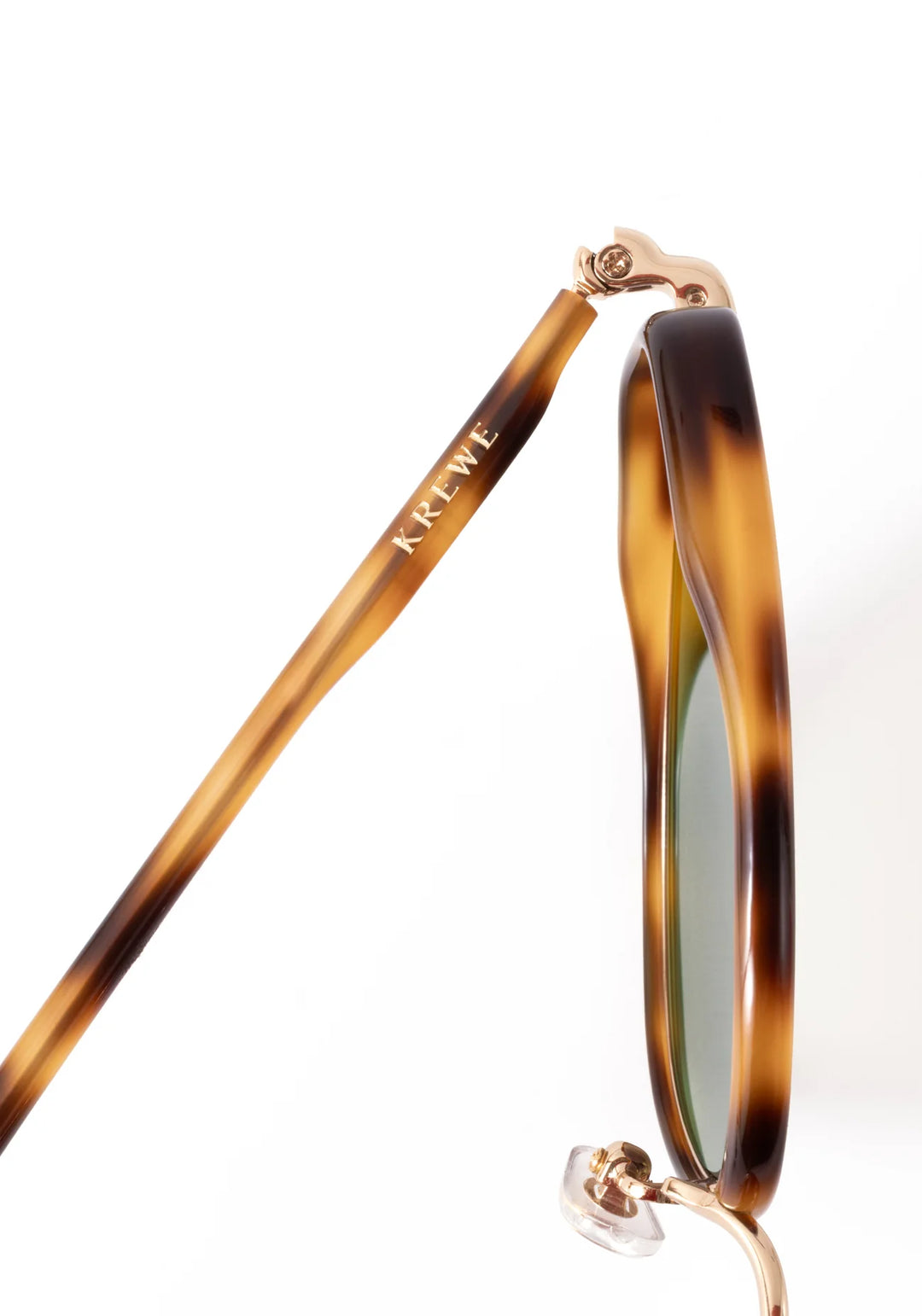 Sunglasses with tortoiseshell frame and green lenses on a white background