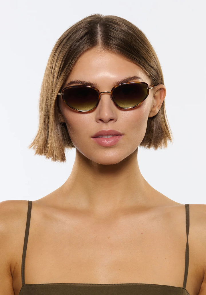 Woman wearing sunglasses with a plain background