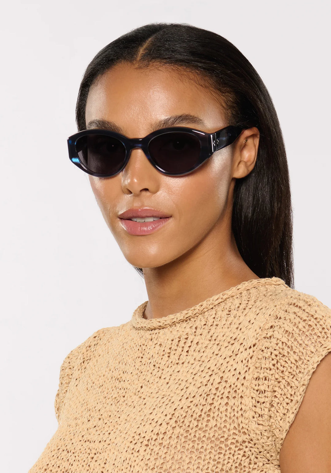 Woman wearing black sunglasses with a plain background