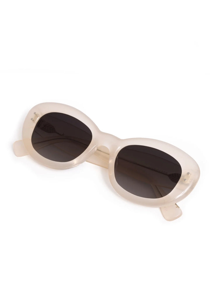 Beige sunglasses with dark lenses on a white background