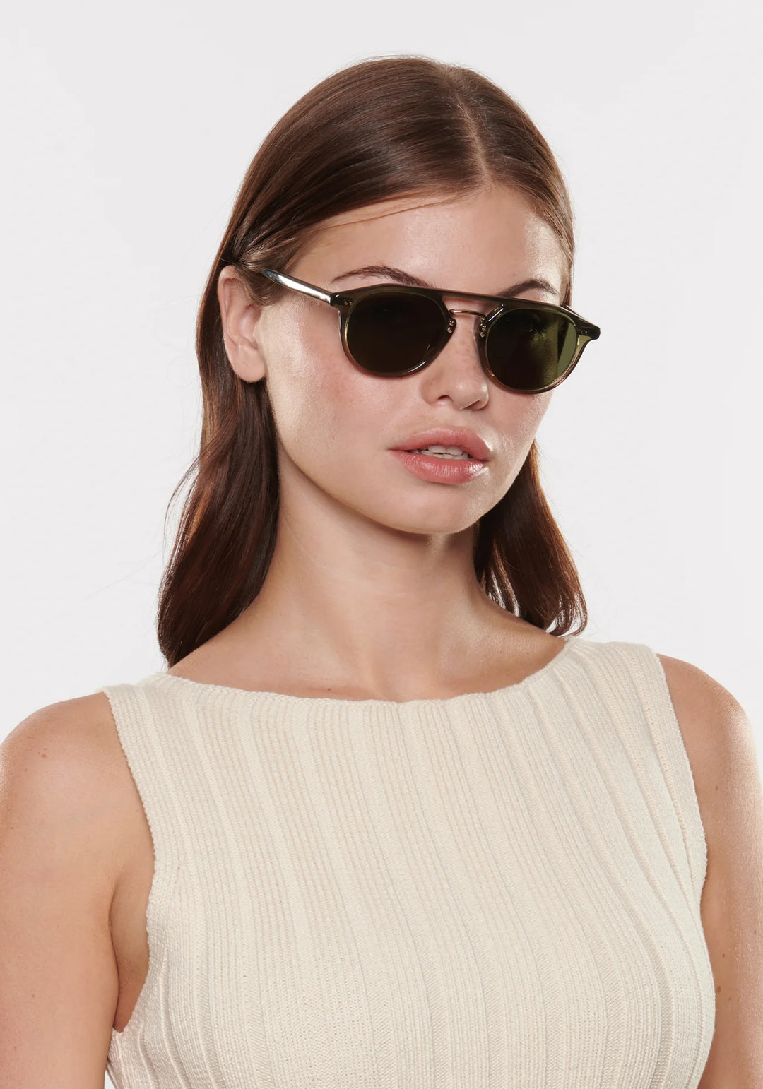 Woman wearing sunglasses with a plain background