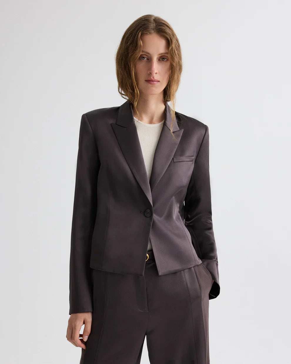 Woman wearing a dark gray suit on a white background