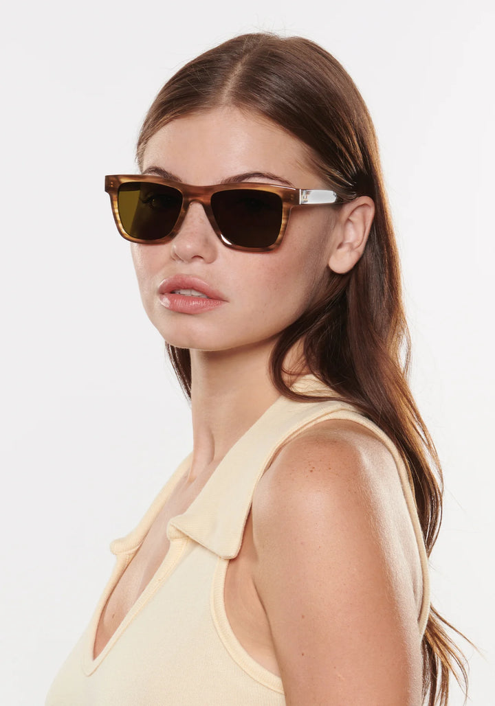 Woman wearing sunglasses with a plain background