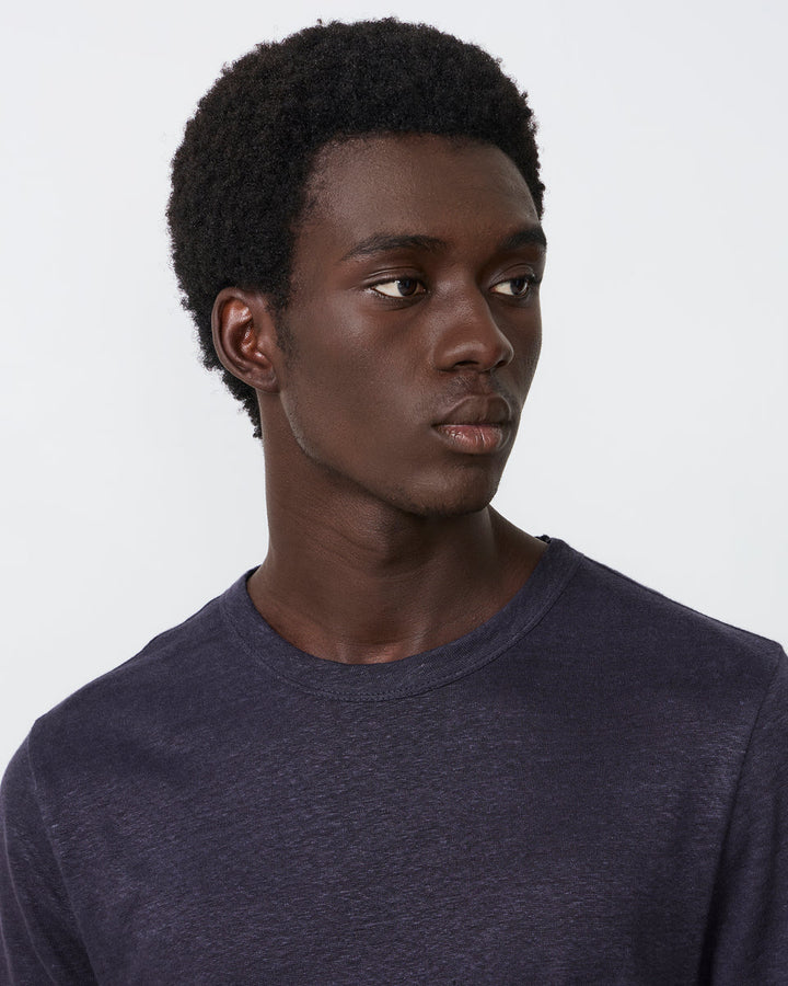 Man wearing a dark blue shirt against a plain background