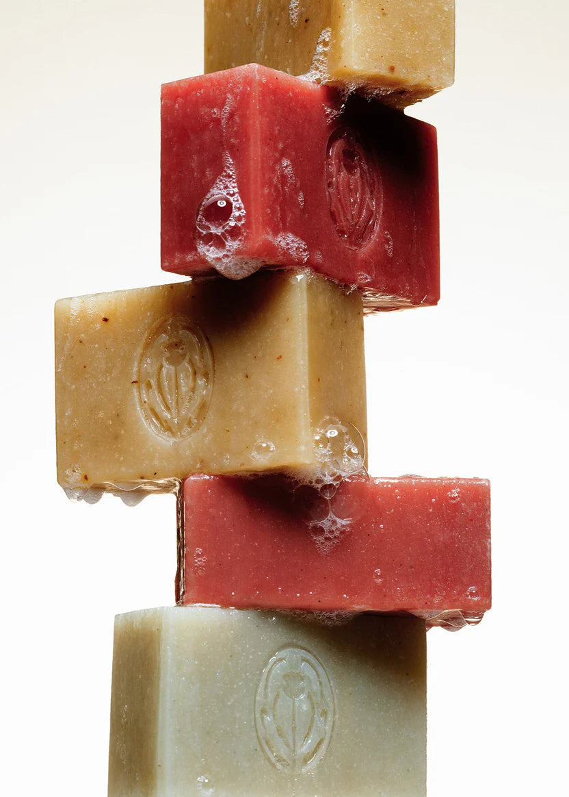 Stack of soap bars in various colors on a white background
