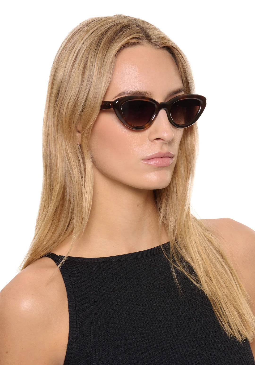 Woman wearing dark sunglasses with a plain background
