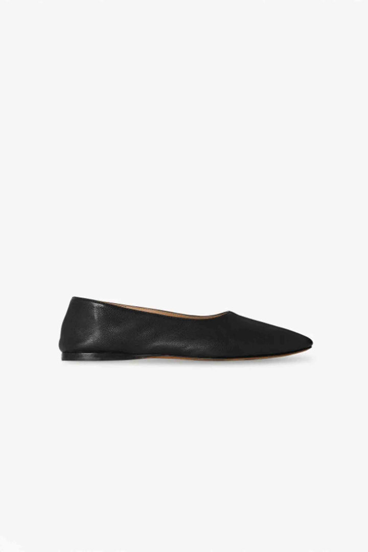 A black grained calfskin leather ballet flat with an oval toe, contrast lining, and leather sole.