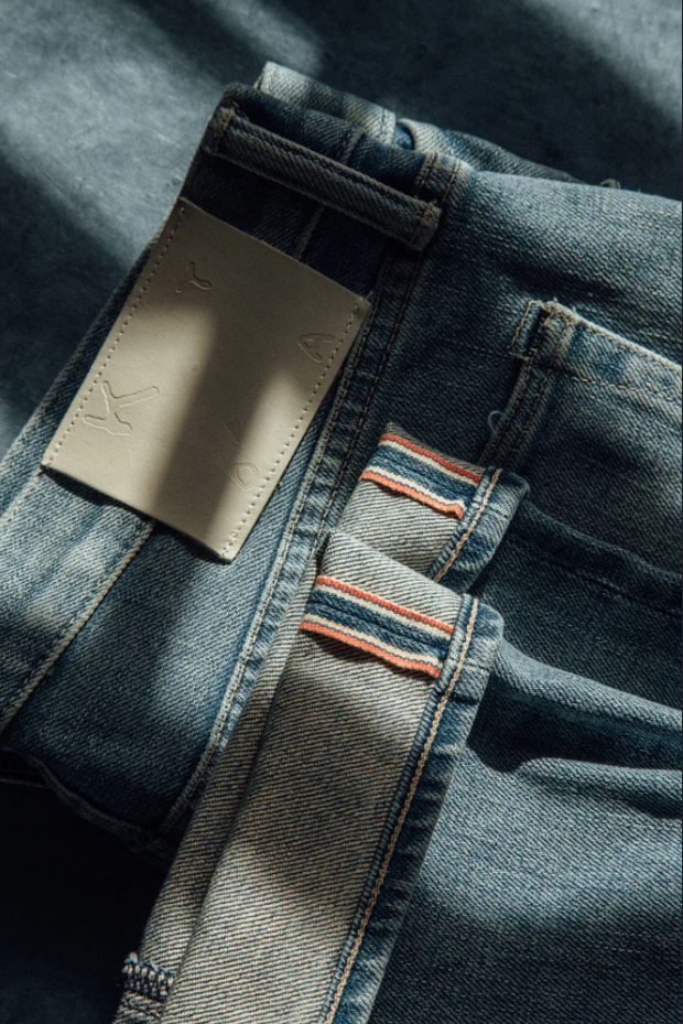 Close-up of a denim jacket with a brand label and striped details.