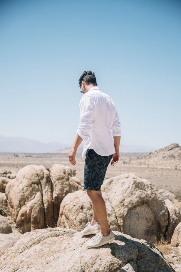 Man standing on rocky terrain with clear blue sky